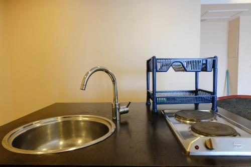 a kitchen counter with a sink and a strainer at Best Location 2BR at Braga City Walk Apartment By Travelio in Bandung