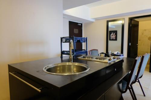 a bathroom counter with a sink in a black counter top at Best Location 2BR at Braga City Walk Apartment By Travelio in Bandung