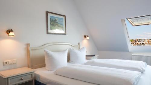 a hotel room with two beds and a window at Hotel Am Yachthafen in Waren