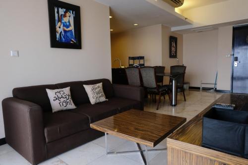 a living room with a couch and a table at Best Location 2BR at Braga City Walk Apartment By Travelio in Bandung