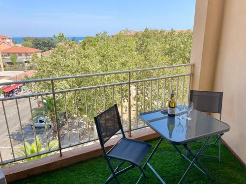 une table et des chaises sur un balcon avec vue dans l'établissement Appartement Saint Aygulf a 300m de la mer, à Fréjus