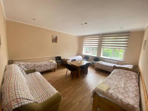 a living room with several couches and a table at Tian-Shan Guest House in Balykchy