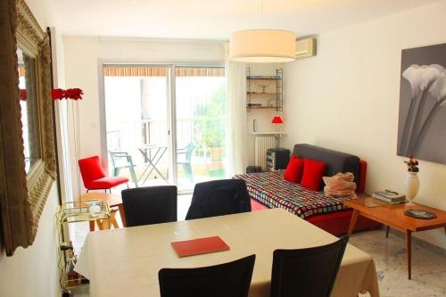 un salon avec une table et des chaises rouges dans l'établissement Nice Family Apartement, à Nice