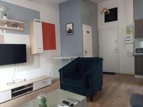 a living room with a blue chair and a tv at WIFI- STADE DE FRANCE- BASILIQUE CATHEDRALE MONSEJOURASAINTDENIS in Saint-Denis