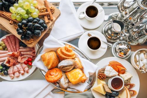 a table with plates of food and cups of coffee at The Biltmore Tbilisi Hotel in Tbilisi City