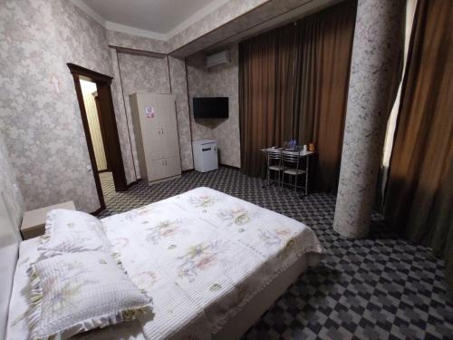 a bedroom with a bed and a television in it at Yulduz Hotel in Andijan
