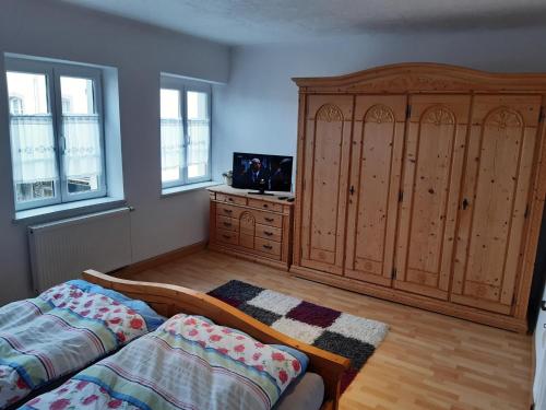 a bedroom with a large wooden cabinet and a bed at Ferienwohnungen Felten in Perl