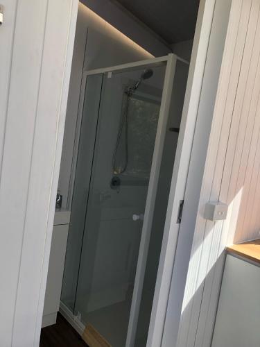 a shower with a glass door in a bathroom at Sandy Strait Shack by Tiny Away in Urangan
