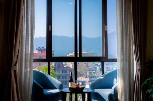 a room with a view of a city from a window at Tuki Resort Pokhara in Pokhara
