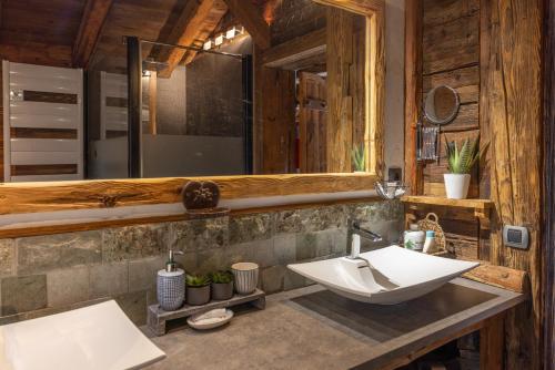 une salle de bain avec un lavabo et un miroir dans l'établissement Chalet montagne Spa, aux Contamines-Montjoie