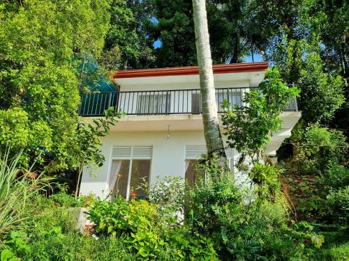 a white house with trees in front of it at Squirrel's Nest in Kandy