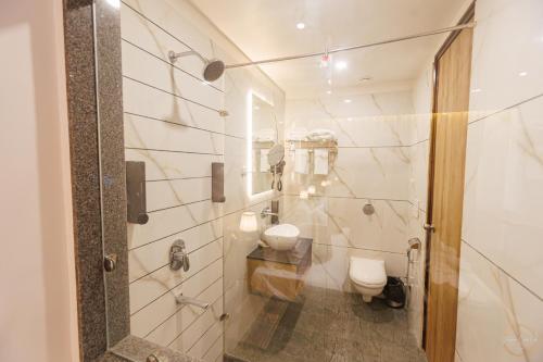 a bathroom with a toilet and a shower at Mannat Residency By iO Hotels Near Golden Temple in Amritsar