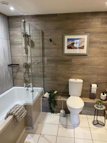 a bathroom with a toilet and a bath tub at The Courtyard Rooms in Brightlingsea
