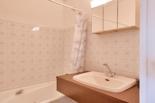 une salle de bain avec un lavabo et une baignoire dans l'établissement À 200m de la plage, appartement vue mer pour 4, à Bénodet