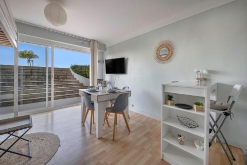 un salon avec un bureau et une table avec des chaises dans l'établissement À 43m de la plage, studio pour 4, à La Baule-les-Pins