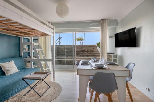 un salon avec une table et un canapé bleu dans l'établissement À 43m de la plage, studio pour 4, à La Baule-les-Pins