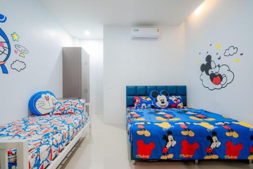 a bedroom with a bed with mickey mouse bedding at พลอยพูลวิลล่า ชะอำ 4 Ploy Poolvilla Cha-am 4 in Cha Am