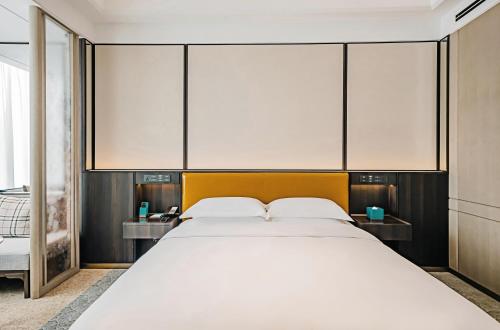 a large white bed in a room with large windows at YTL ChangChengYunYue Hotel in Wenzhou