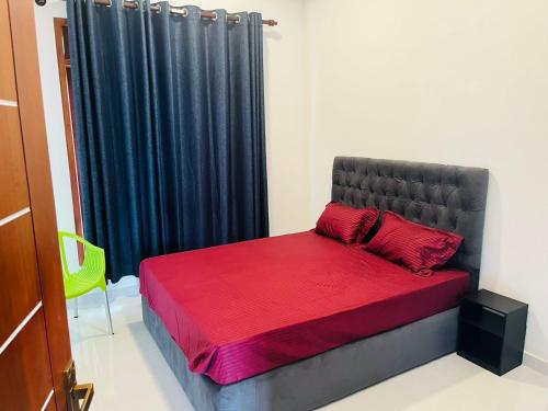 a bedroom with a bed and a black curtain at Seethawaka Layover in Kosgama