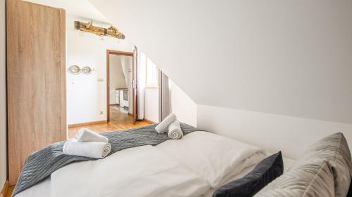 a white bed in a room with a staircase at Aparthotel Delta Białka in Białka Tatrzanska