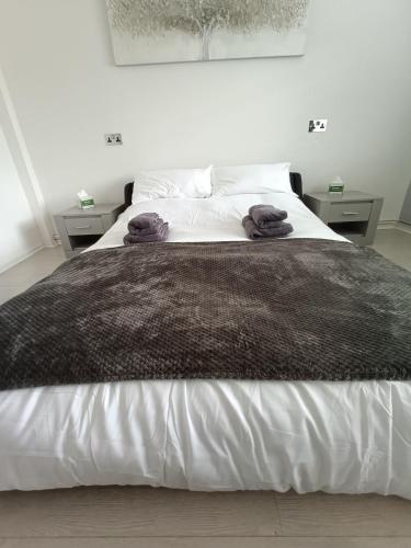 a bedroom with a large bed with brown blankets on it at Alton Towers & Foxtail Barns & Oak Barns & Peak District in Wetleyrocks