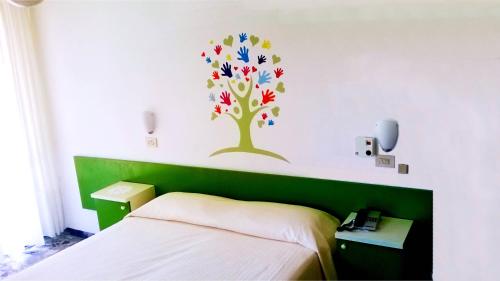 1 dormitorio con un árbol en la pared en Hotel Astor, en Silvi Marina