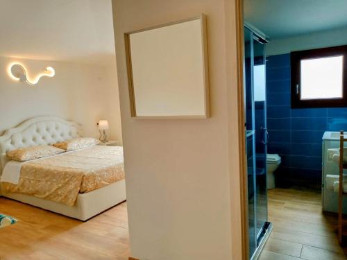 a bedroom with a bed and a mirror and a bathroom at La Grotta Sardegna 3 Bedrooms in Urzulei