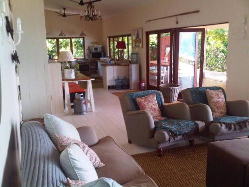 a living room with two couches and a kitchen at Mar Azul 14 in Ponta Malongane