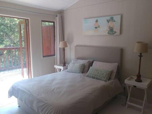 a bedroom with a white bed and a window at Mar Azul 14 in Ponta Malongane