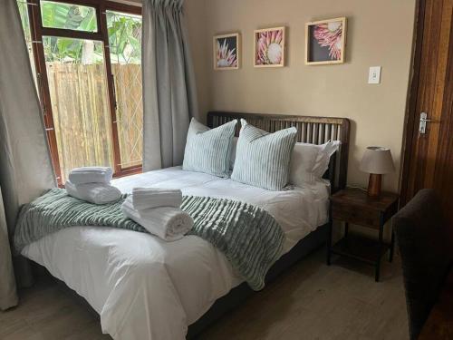 ein Schlafzimmer mit einem Bett mit Handtüchern darauf in der Unterkunft Forest Drive Cottage in Kloof