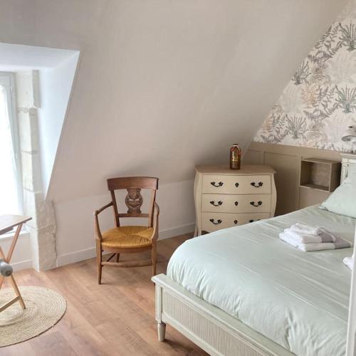 - une chambre avec un lit, une chaise et une commode dans l'établissement Superbe Lodge 4-8 pers à 15 mn zoo Beauval, à Faverolles