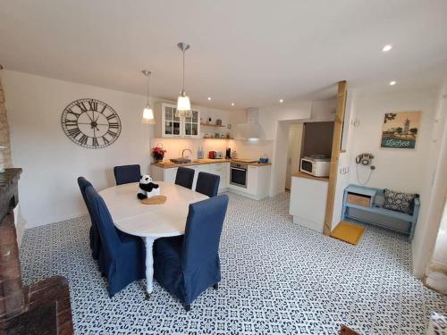 une cuisine et une salle à manger avec une table et des chaises bleues dans l'établissement Superbe Lodge 4-8 pers à 15 mn zoo Beauval, à Faverolles