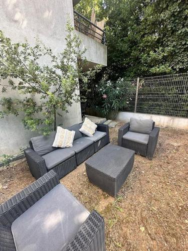 d'une terrasse avec des canapés et des chaises dans la cour. dans l'établissement Appartement du M T2 Montpellier, à Montpellier