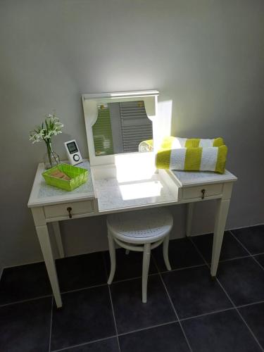 a white desk with a mirror and a chair at No2 La Place in Tourbes