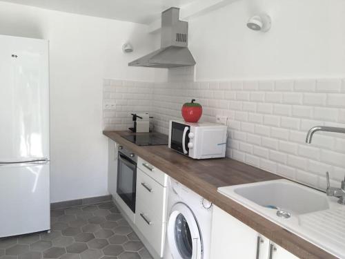 - une cuisine avec un comptoir, un four micro-ondes et un évier dans l'établissement Appartement avec terrasse et vue mer, à Calcatoggio