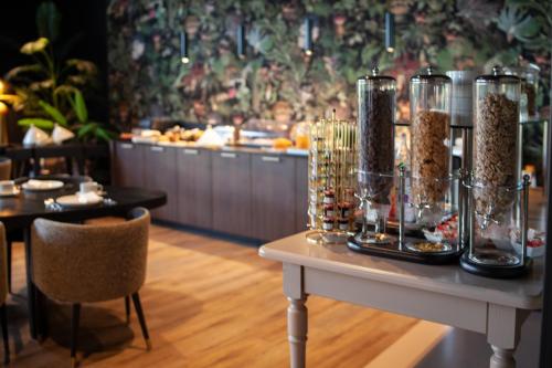 a table with a buffet of food in a restaurant at The Originals Boutique, La Maison Rouge, Lens Ouest in Noeux-les-Mines