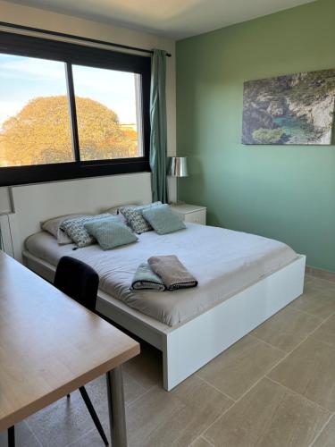 une chambre avec un lit avec une grande fenêtre dans l'établissement les Alizés, à Marseille