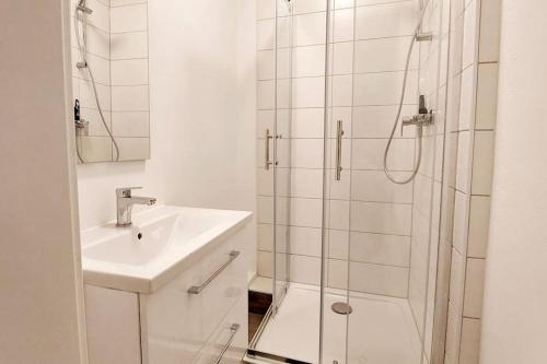 un bagno bianco con lavandino e doccia di zentrale Ferienwohnung - direkt am See und in Schlossnähe a Schwerin
