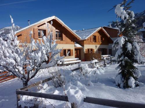 a log cabin in the snow with a fence at Le Chalet Pastorale Pied Des Pistes in Les Orres