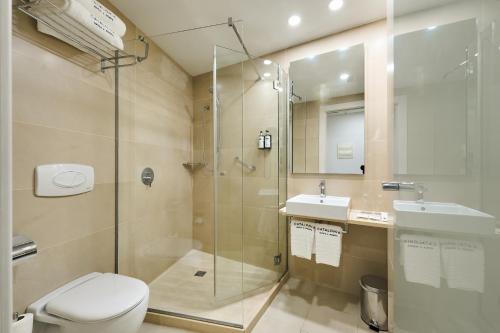 a bathroom with a shower and a toilet and a sink at Catalonia La Boquería in Barcelona