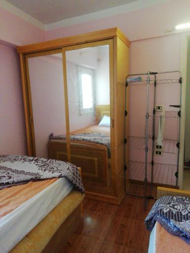 a small bedroom with two beds and a mirror at Panda House in Alexandria