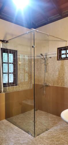 a bathroom with a glass shower with a tub at Hantana Forest Reserve Inn in Kandy