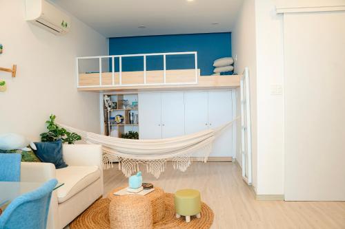 a living room with a couch and a hammock at Sunrise from bed Apartment - NhaTrang Beach in Nha Trang