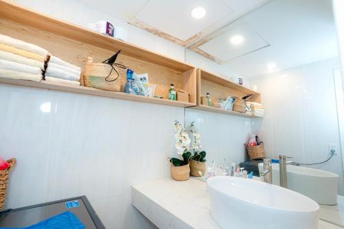 a bathroom with a white sink and a toilet at Sunrise from bed Apartment - NhaTrang Beach in Nha Trang