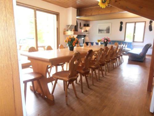 une grande salle à manger avec une longue table et des chaises dans l'établissement Chalet St Victoire - Les Orres, aux Orres