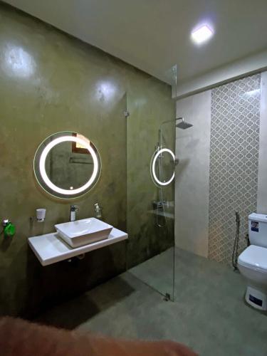 a bathroom with a sink and a shower with a mirror at Hotel Vish Ceylon in Talawatugoda