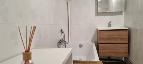 une salle de bain blanche avec une baignoire et un lavabo dans l'établissement Les Aubépines, à Rancennes