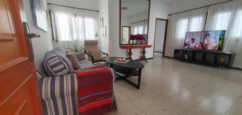 a living room with a couch and a tv at Casa maria in Puerto del Rosario