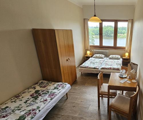 a room with two beds and a table and a dining room at Hotel Chytrov in Volfířov
