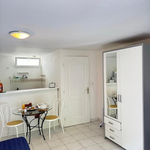 une cuisine avec une table et des chaises dans une pièce dans l'établissement Studio Cosy en pleine nature, à Saint-Jouan-des-Guérets